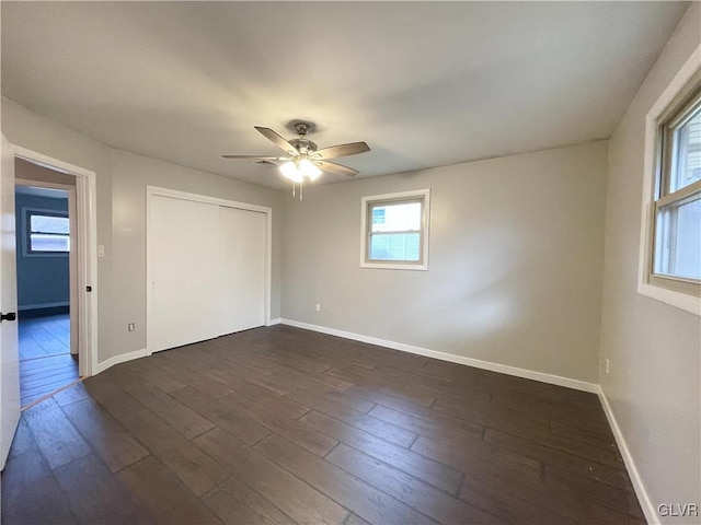 empty room featuring ceiling fan, dark hardwood / wood-style floors, and a healthy amount of sunlight