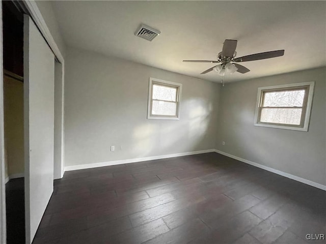 unfurnished bedroom with dark hardwood / wood-style flooring, a closet, and ceiling fan