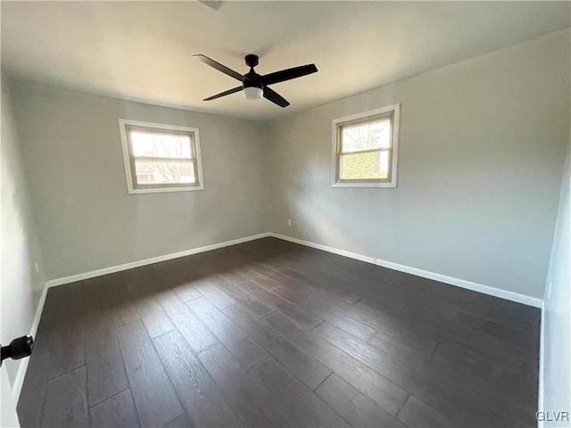 empty room with plenty of natural light, dark hardwood / wood-style floors, and ceiling fan