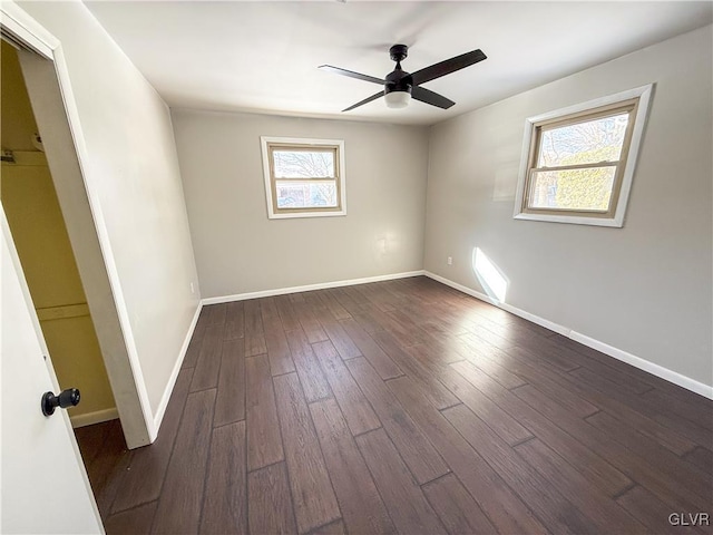 empty room featuring dark wood-type flooring and ceiling fan