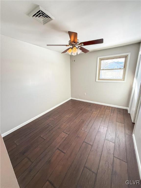 spare room with ceiling fan and dark hardwood / wood-style flooring