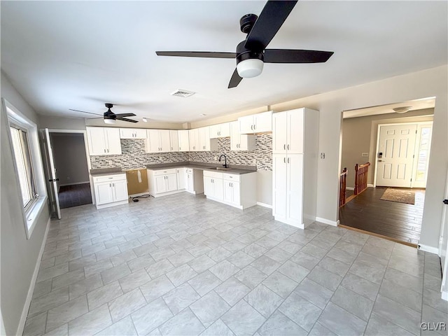 kitchen featuring backsplash, sink, and white cabinets