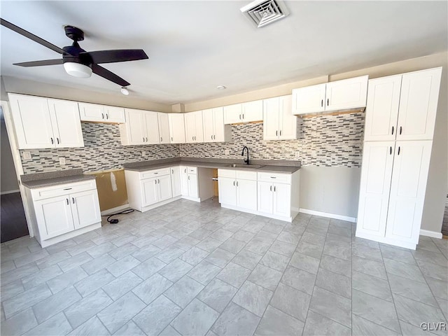 kitchen with sink, white cabinets, and decorative backsplash