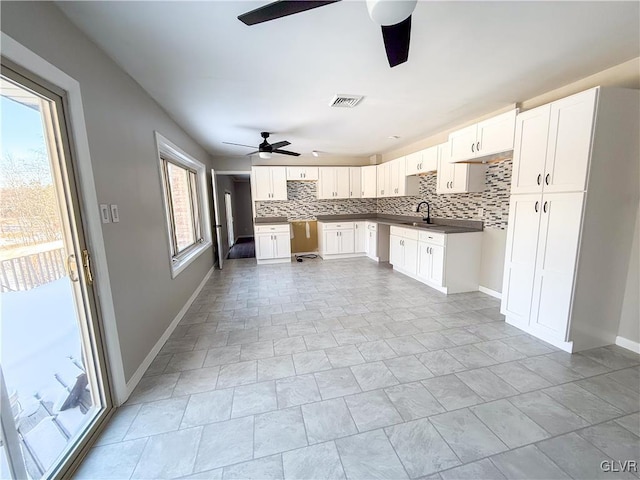 kitchen with ceiling fan, sink, decorative backsplash, and white cabinets