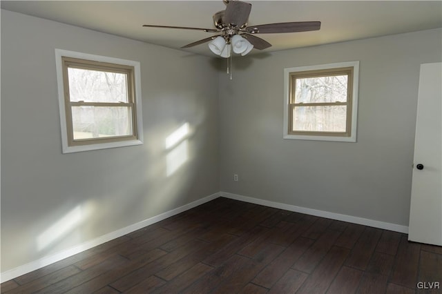 empty room with plenty of natural light, dark hardwood / wood-style floors, and ceiling fan