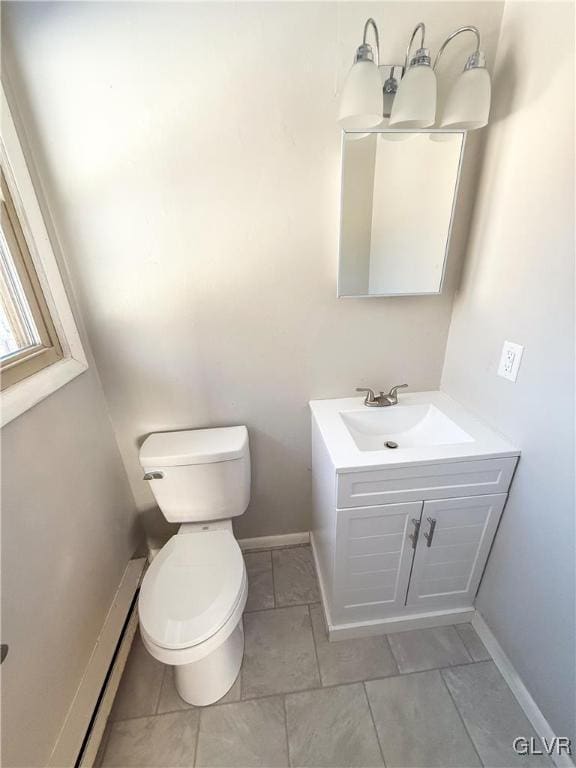 bathroom featuring vanity, baseboard heating, and toilet