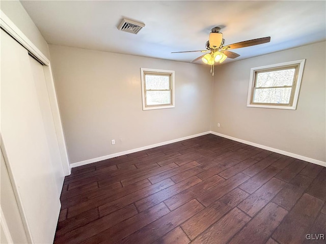 unfurnished bedroom with dark wood-type flooring, ceiling fan, and a closet