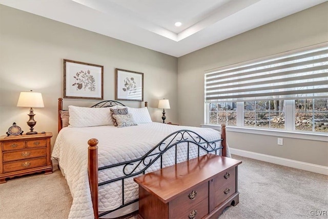 carpeted bedroom featuring a tray ceiling