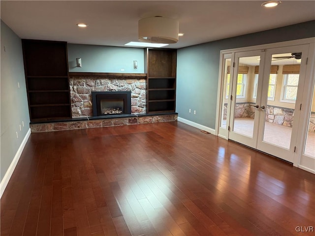 unfurnished living room with french doors, wood-type flooring, a fireplace, and built in features