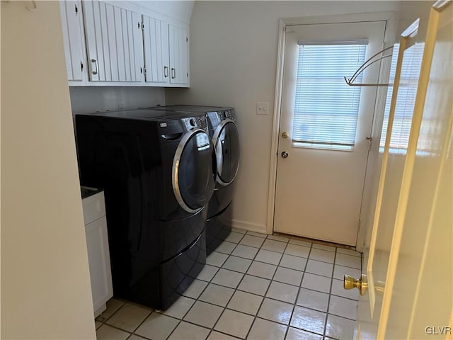 washroom featuring cabinets, light tile patterned flooring, and separate washer and dryer