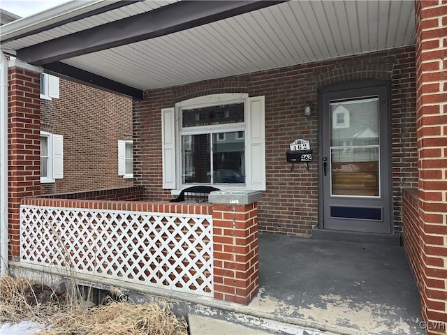 view of exterior entry featuring covered porch