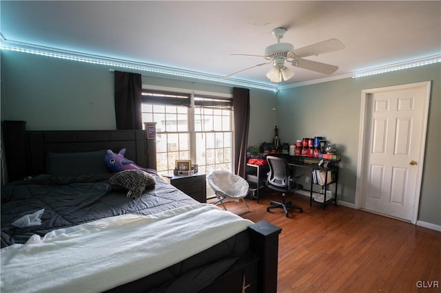 bedroom featuring wood-type flooring, ornamental molding, and ceiling fan