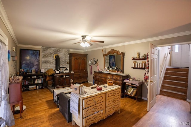 living room featuring hardwood / wood-style flooring, ornamental molding, and a wood stove