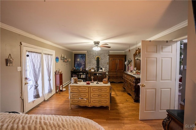 bedroom with ornamental molding, a wood stove, hardwood / wood-style floors, and ceiling fan