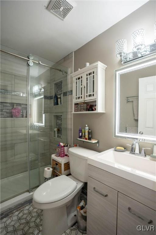 bathroom with vanity, a shower with shower door, and toilet