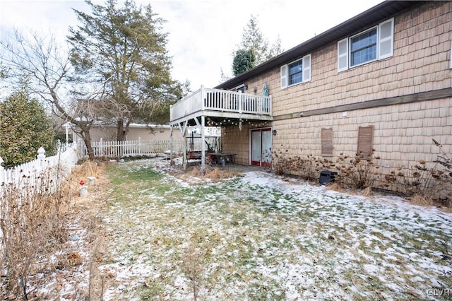 snow covered rear of property with a wooden deck