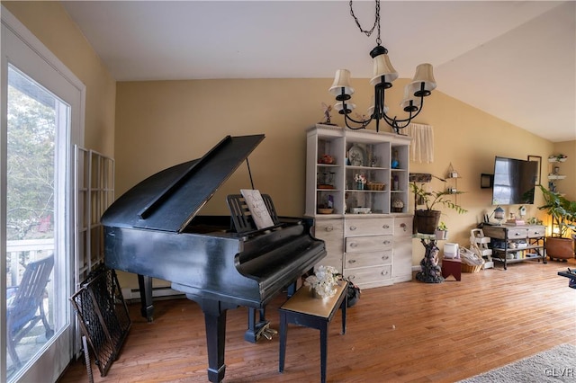 misc room with vaulted ceiling, hardwood / wood-style floors, and a notable chandelier