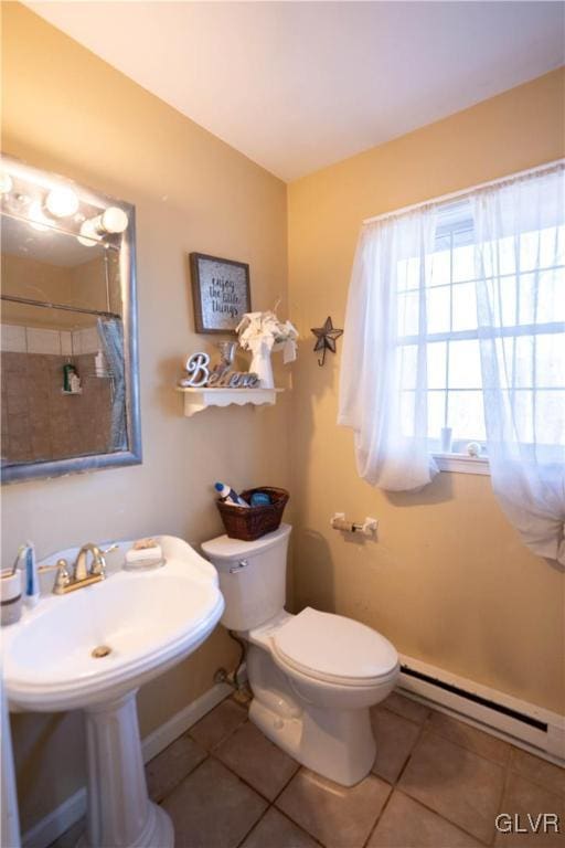 bathroom with a baseboard heating unit, tile patterned floors, sink, and toilet