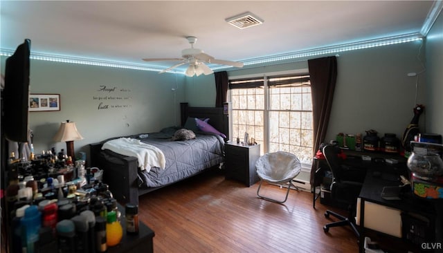 bedroom featuring wood-type flooring, ornamental molding, and ceiling fan