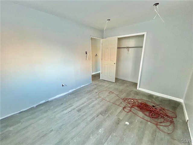 unfurnished bedroom featuring hardwood / wood-style floors and a closet