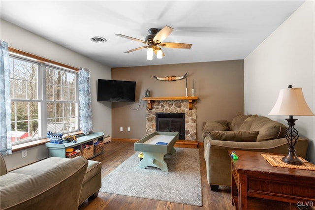 living room featuring dark hardwood / wood-style flooring, a fireplace, and ceiling fan