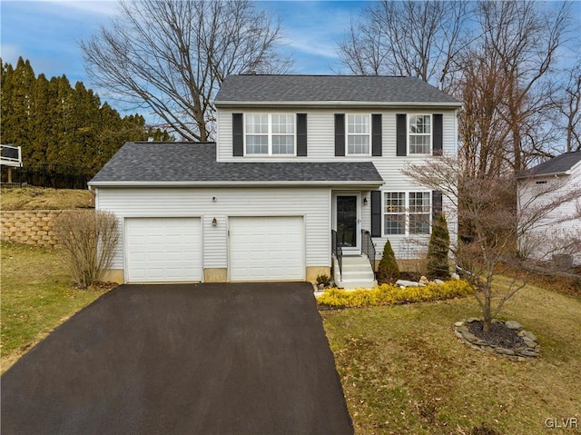 view of property with a garage and a front lawn