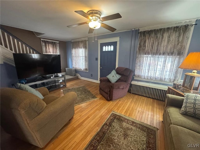 living room with ceiling fan, radiator heating unit, and light hardwood / wood-style flooring