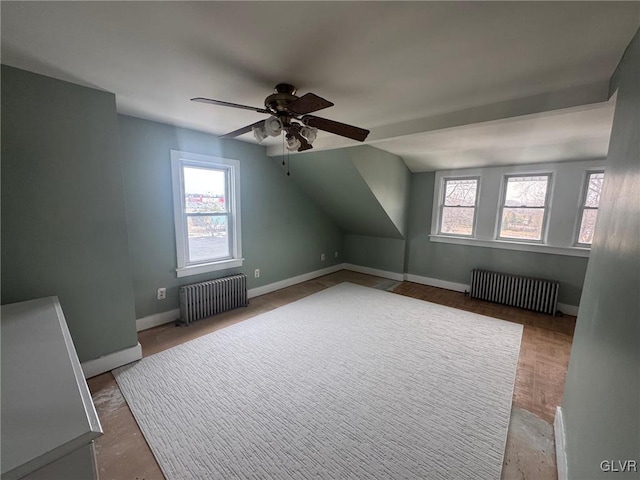 bonus room featuring ceiling fan, radiator, and a wealth of natural light