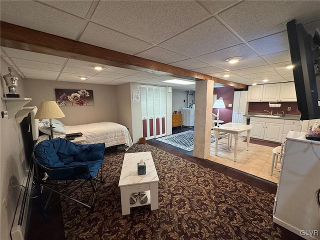 bedroom with a baseboard radiator, sink, a paneled ceiling, and ensuite bath