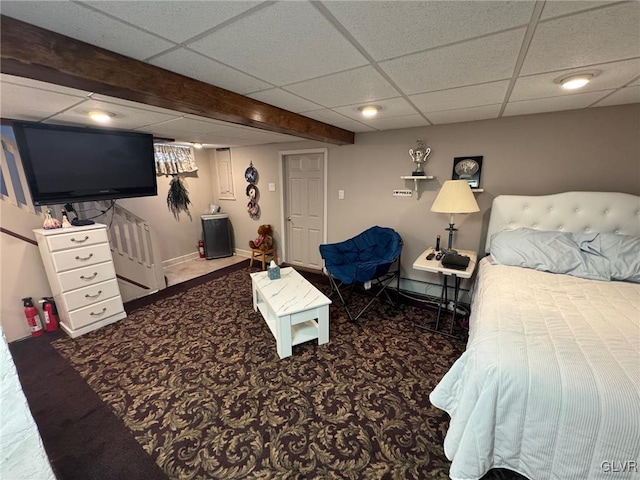 carpeted bedroom featuring a drop ceiling