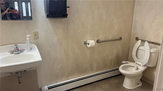 bathroom featuring tile patterned flooring, a baseboard heating unit, sink, and toilet