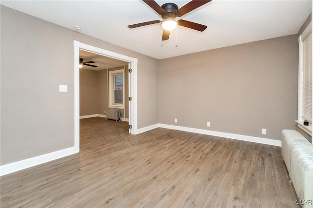 empty room featuring radiator and light wood-type flooring