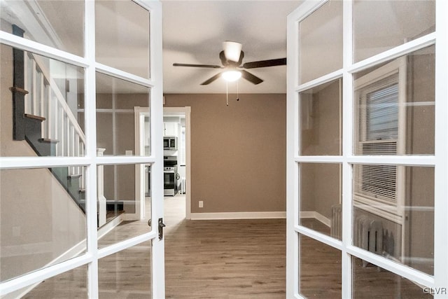 interior space with hardwood / wood-style flooring, french doors, and ceiling fan