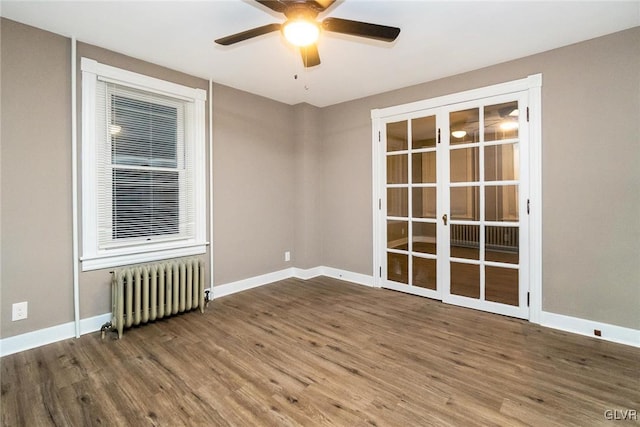 spare room featuring french doors, ceiling fan, wood-type flooring, and radiator