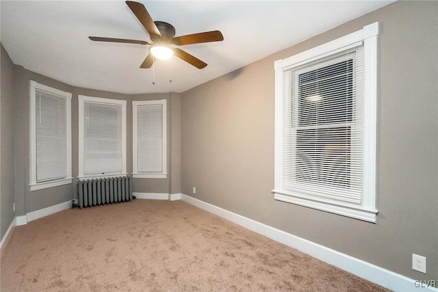 empty room with radiator heating unit, light colored carpet, and ceiling fan