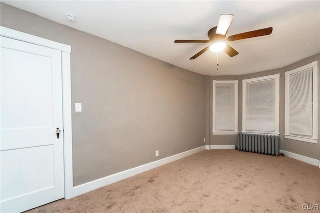 carpeted spare room with radiator and ceiling fan