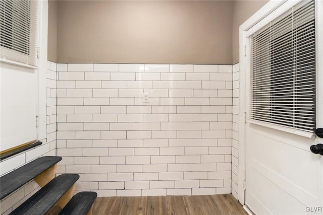 bathroom with hardwood / wood-style floors and tile walls