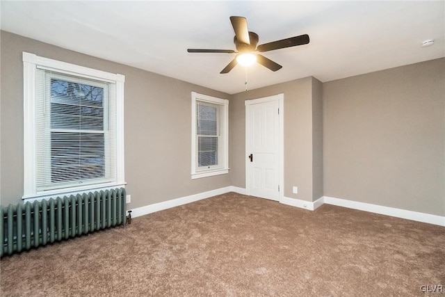 carpeted spare room with radiator heating unit and ceiling fan