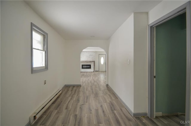 hall with hardwood / wood-style floors and a baseboard heating unit