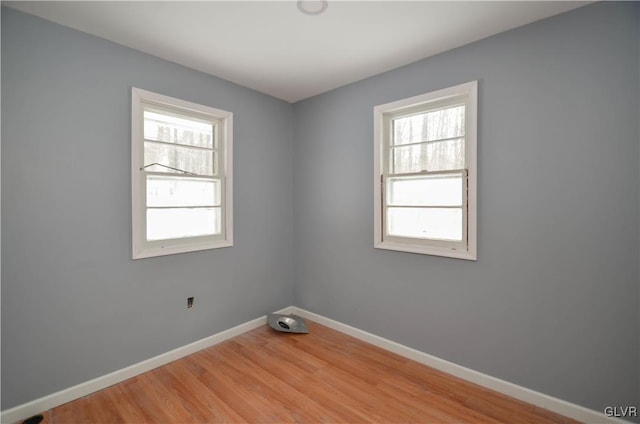 empty room with wood-type flooring and a wealth of natural light