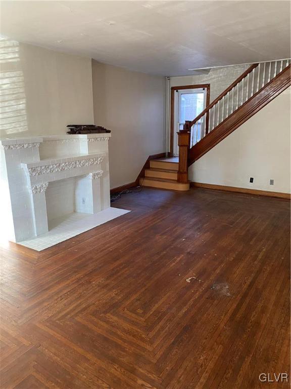 unfurnished living room featuring dark parquet flooring