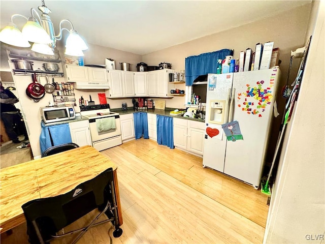 kitchen featuring white appliances, white cabinetry, light wood-type flooring, dark countertops, and decorative light fixtures