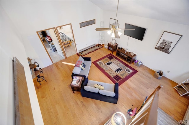 living room featuring a baseboard radiator, high vaulted ceiling, hardwood / wood-style floors, and ceiling fan