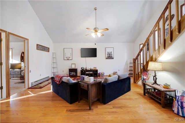 living room featuring high vaulted ceiling, a baseboard heating unit, ceiling fan, and light hardwood / wood-style flooring