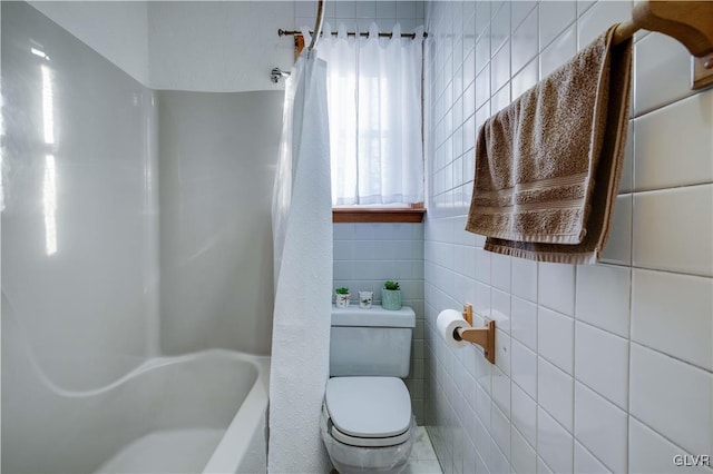 bathroom with toilet and tile walls