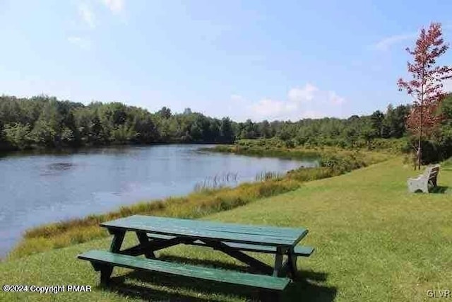 view of property's community with a yard and a water view