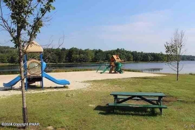 view of jungle gym with a water view and a lawn