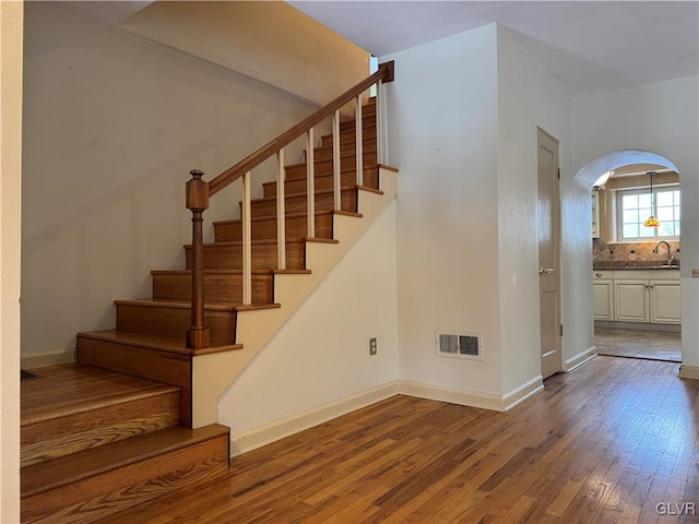 staircase with sink and hardwood / wood-style floors