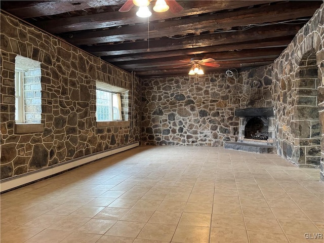 basement with light tile patterned flooring, ceiling fan, a fireplace, and a baseboard heating unit