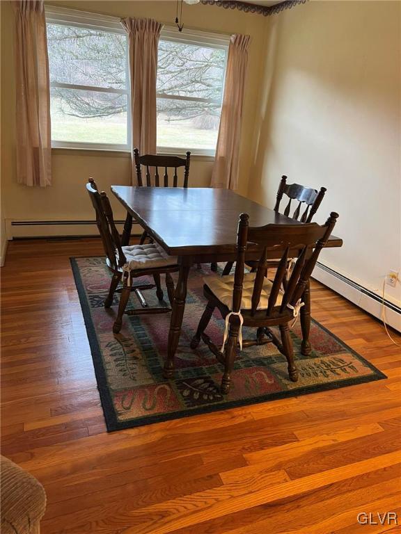 dining area with wood-type flooring and a baseboard radiator